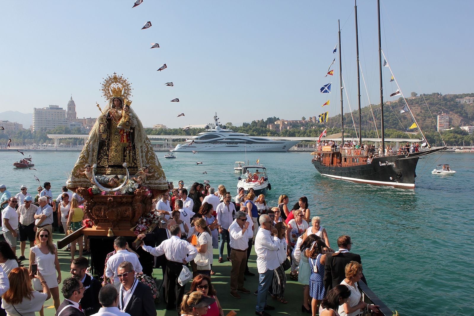 Turistas observan a la Virgen del Carmen con la ciudad al fondo.