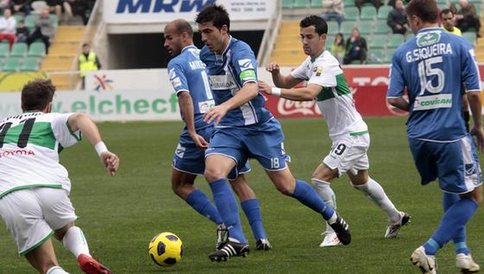 Lucena conduce la pelota acosado por dos jugadores del Elche. / LOF