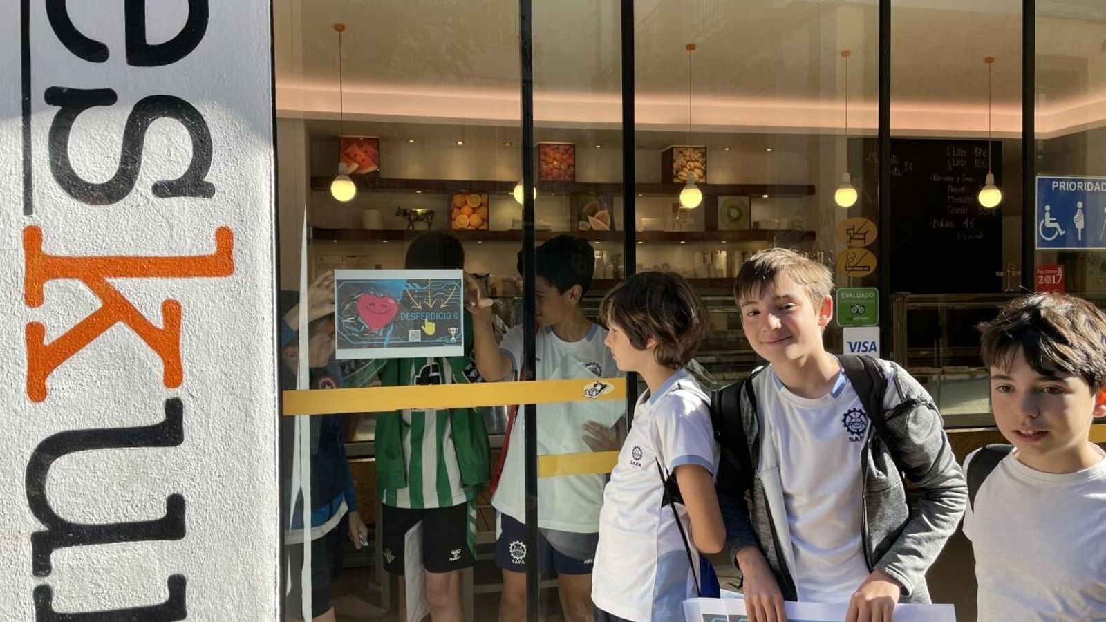 Los estudiantes colocando los carteles que promocionan el 'Proyecto Desperdicio 0'.