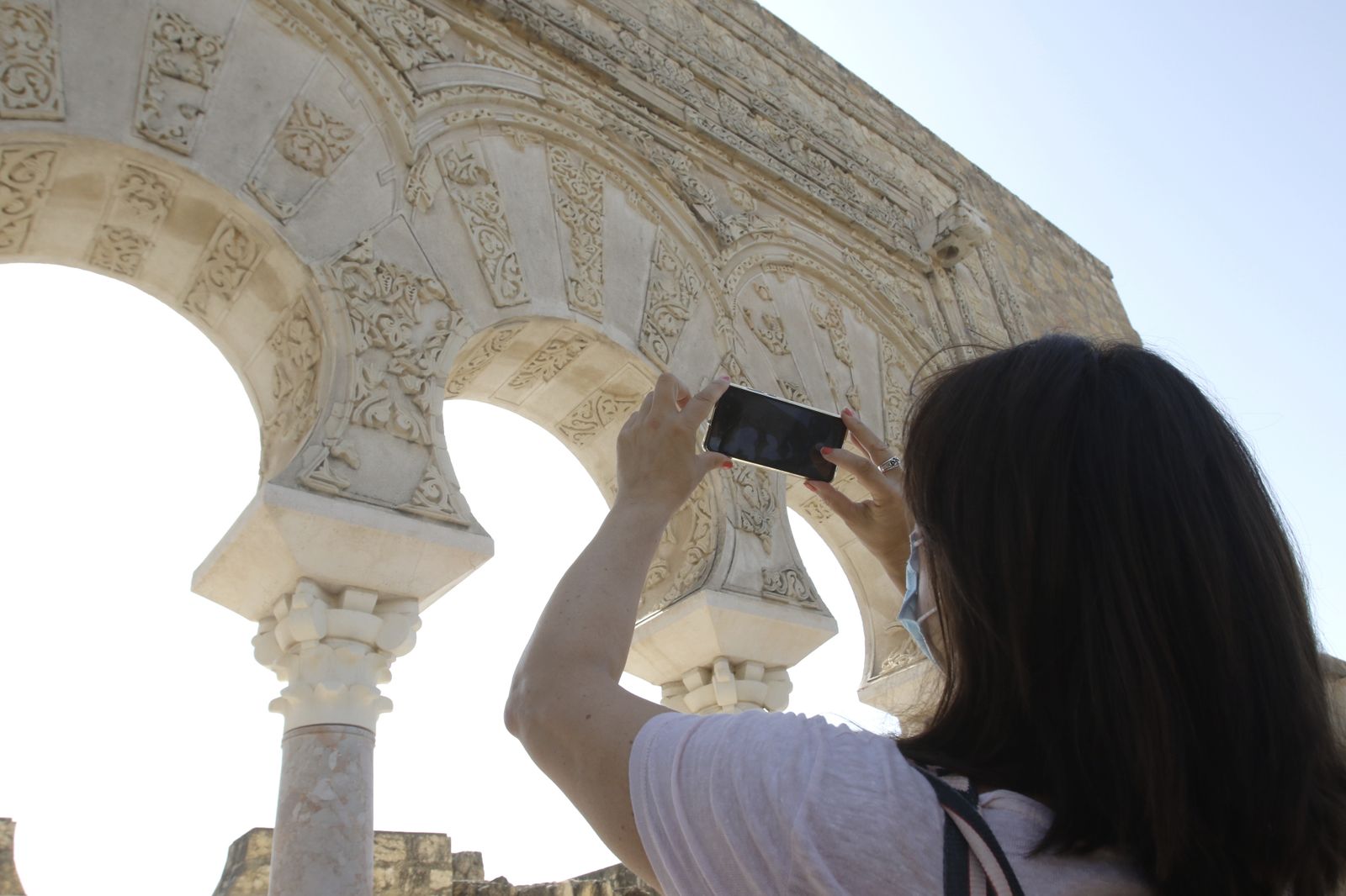 Una mujer toma una fotografía durante una visita a Medina Azahara.