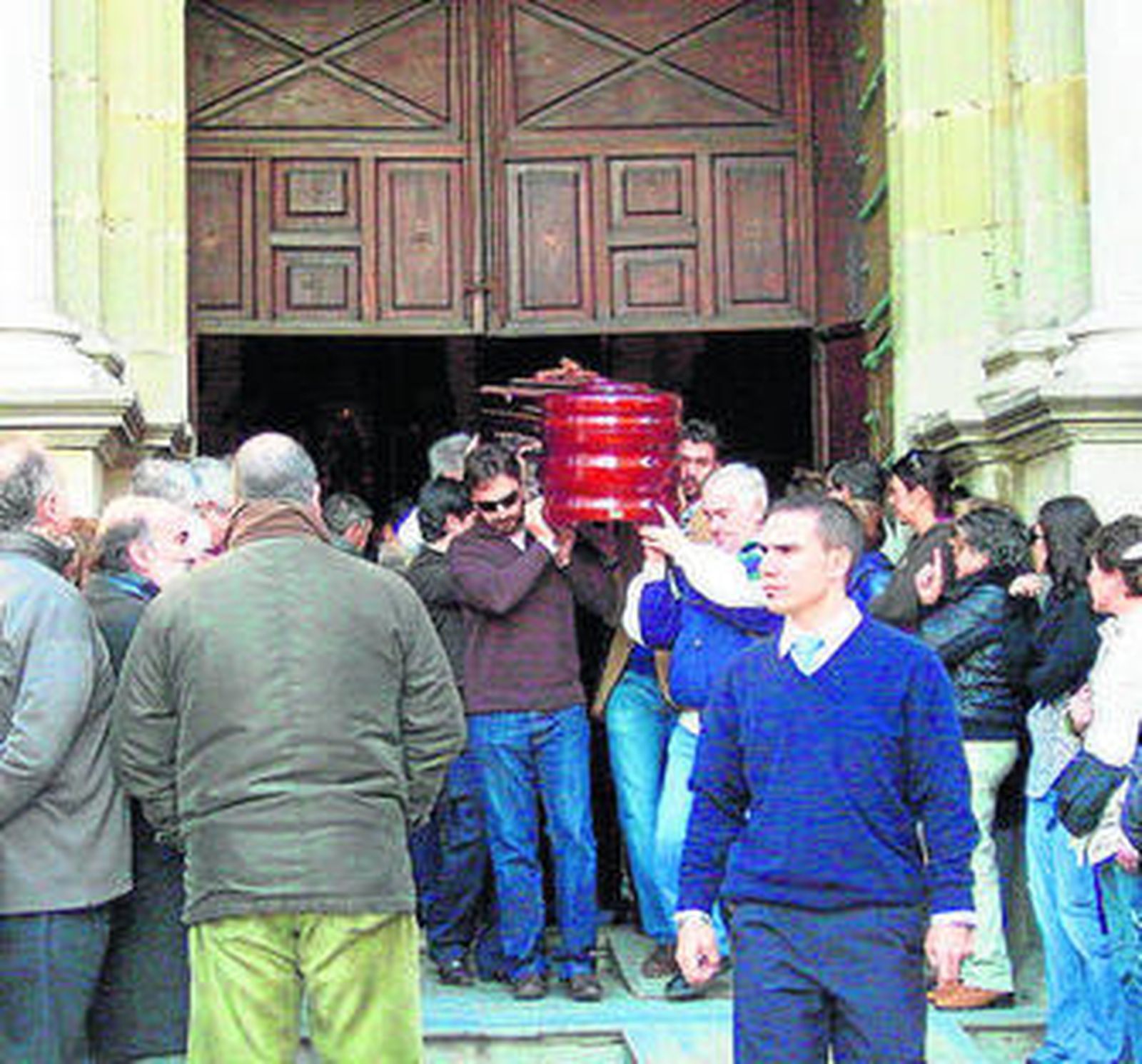 Familiares y amigos acompañan la salida del féretro.