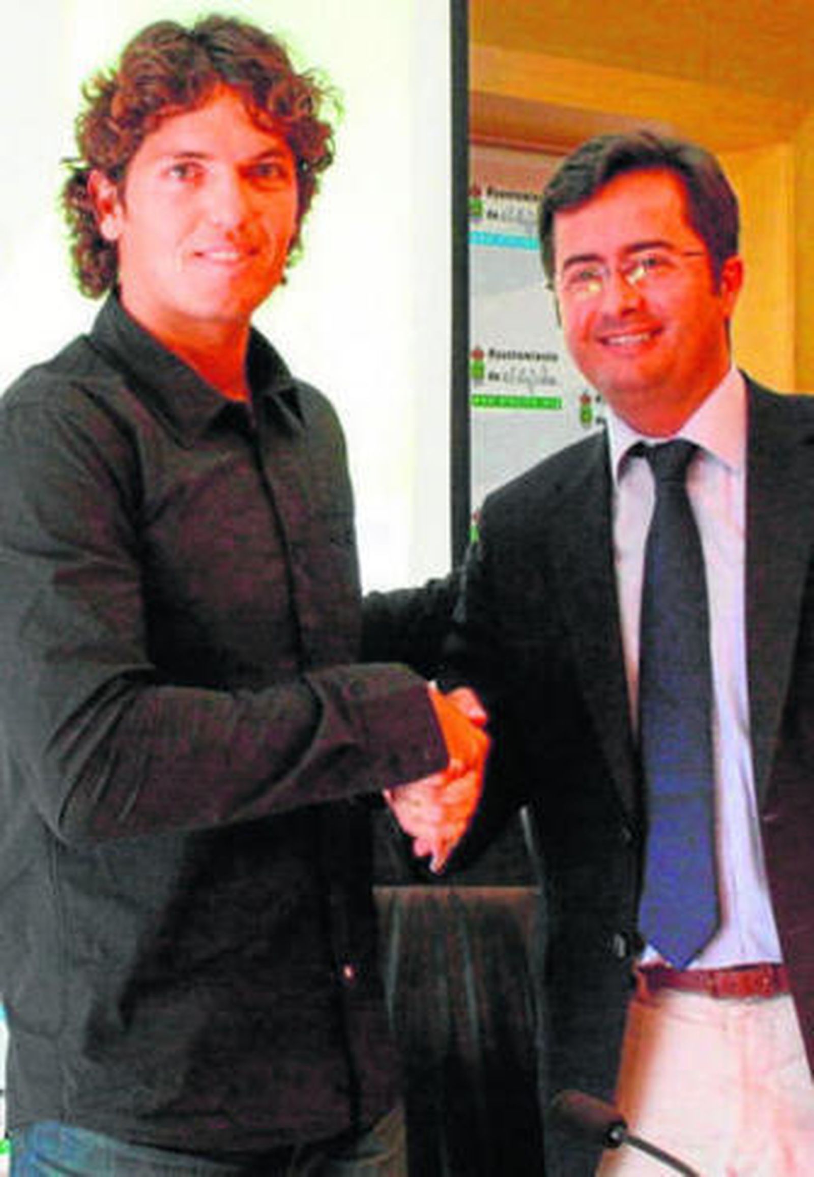 Ambos protagonistas posan tras la rúbrica del acuerdo.