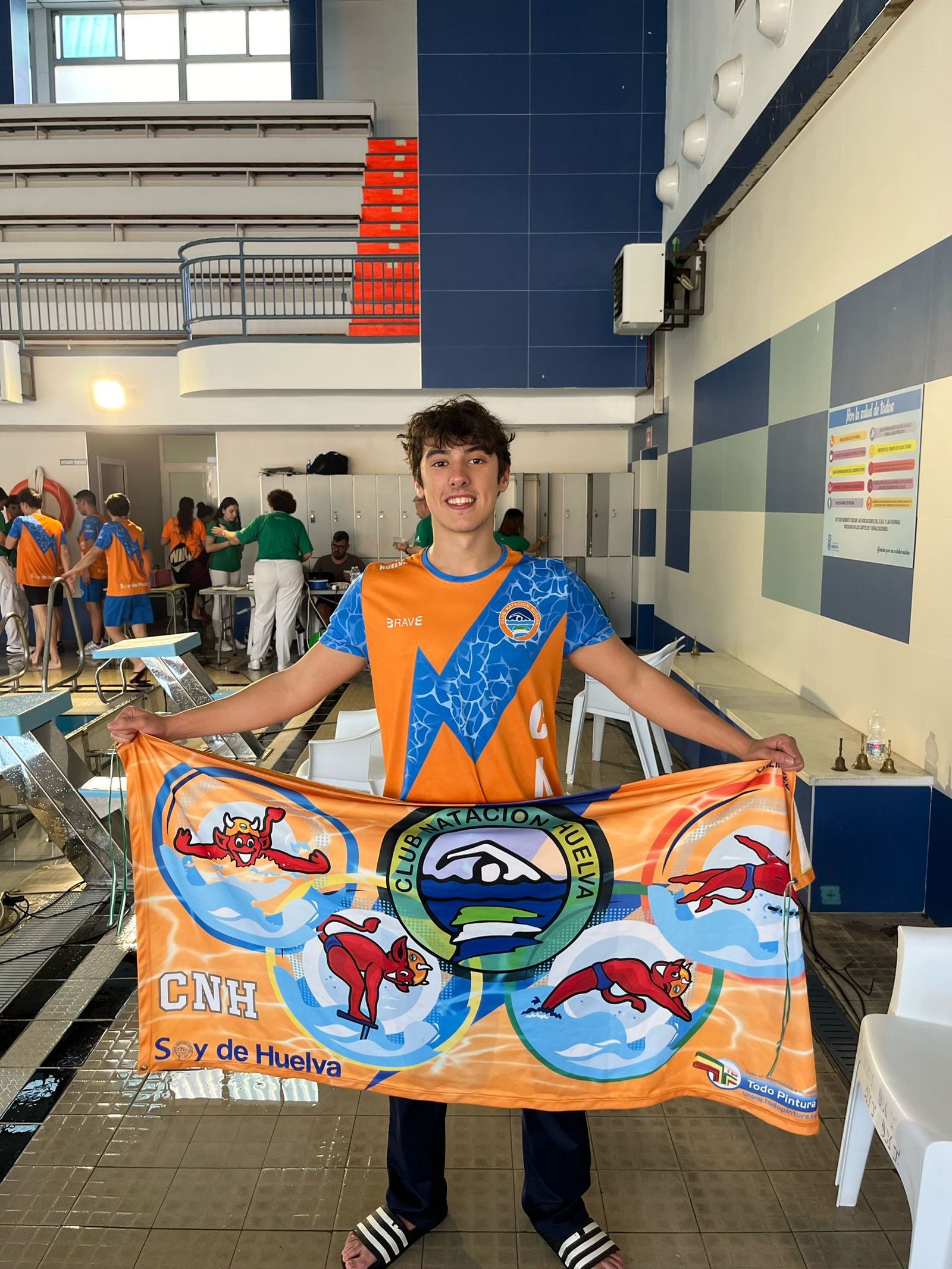 Samuel Gómez posa con la bandera del Club Natación Huelva.