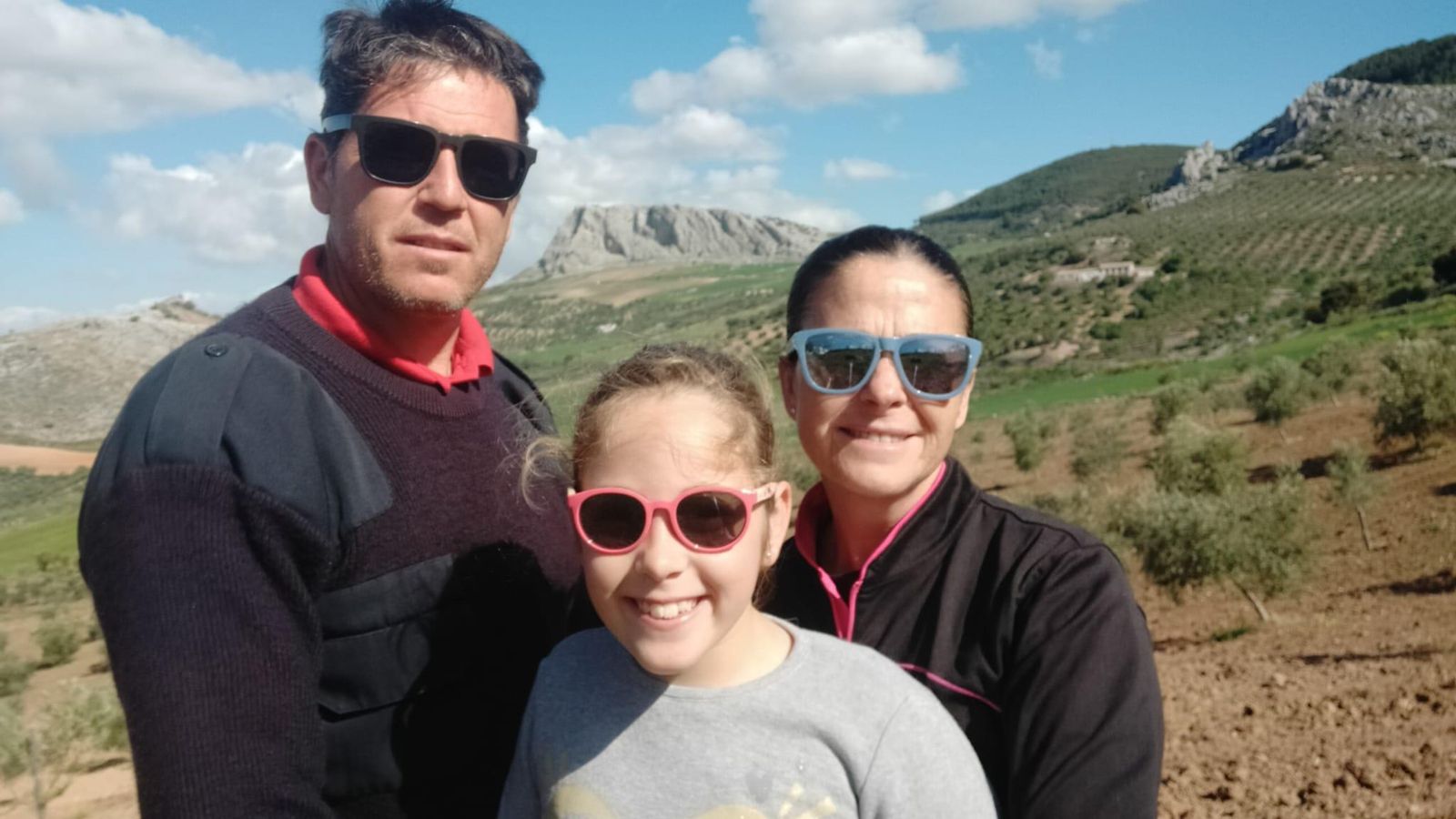 Vito junto a su mujer, Paqui, y su hija, Lola, con el campo al fondo.
