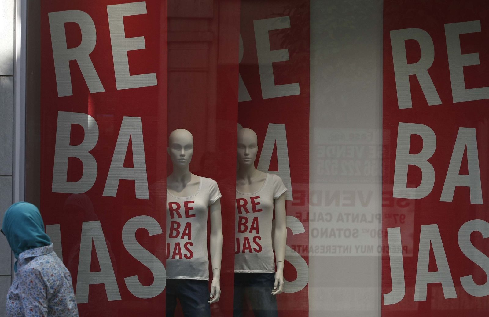 Una mujer pasa por delante de un escaparate de rebajas, ayer en Algeciras.