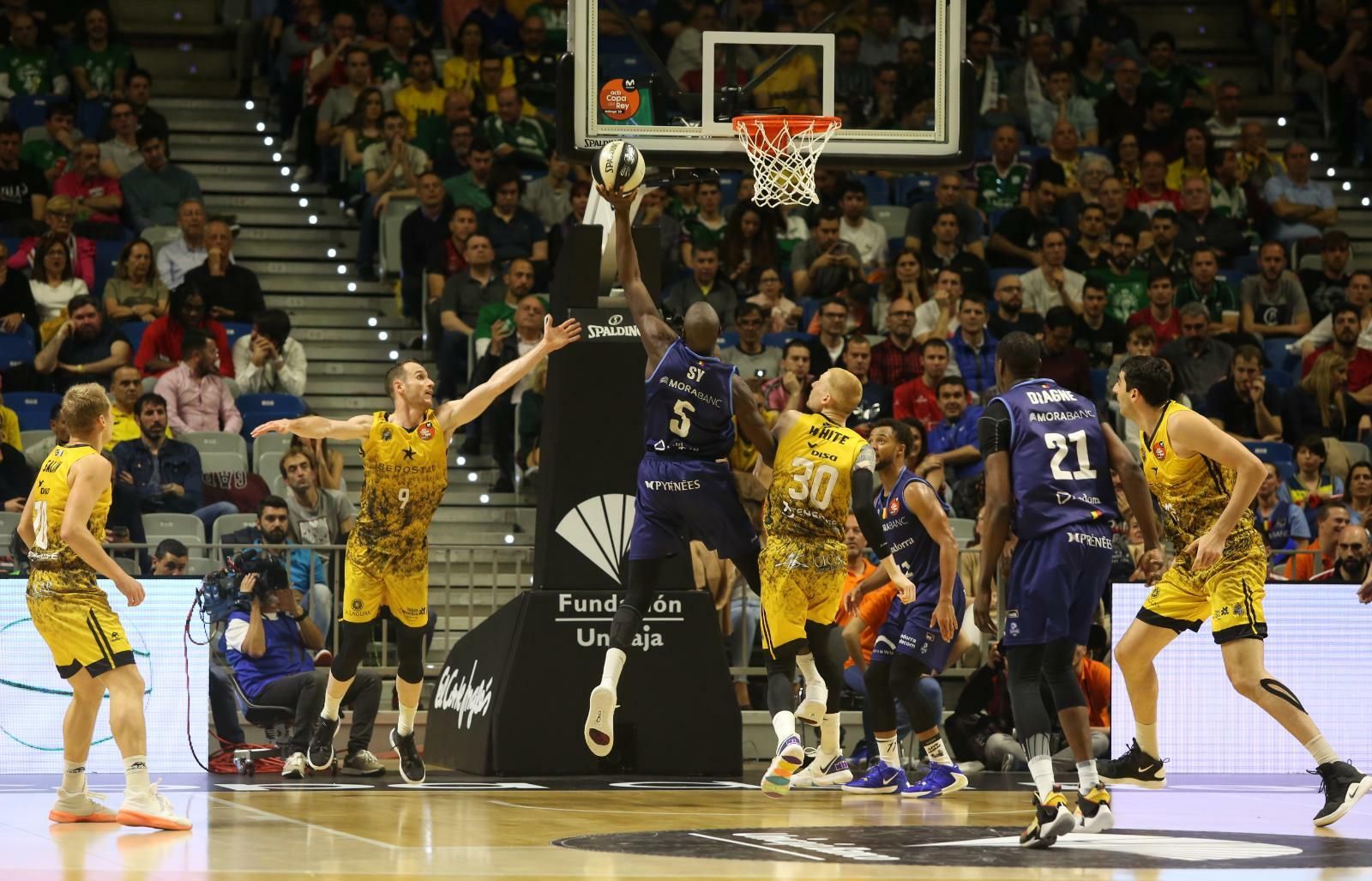 Sy lanza a canasta ante la defensa de White