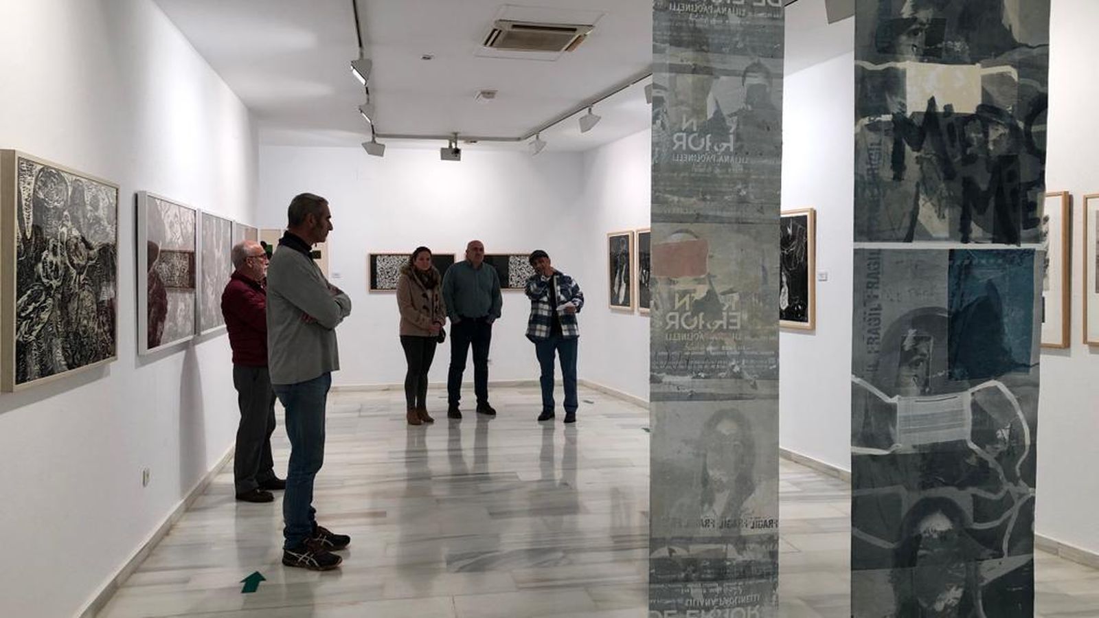 Varios visitantes en la exposición 'El Color del Covid'.