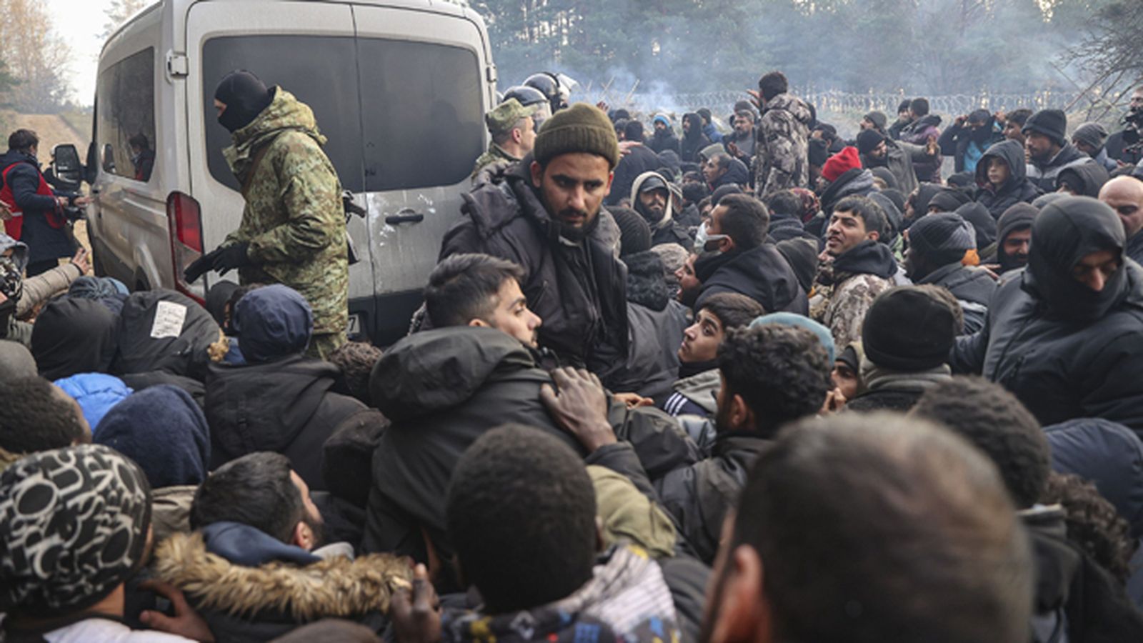 Migrantes aguardan ayuda de soldados bielorrusos.