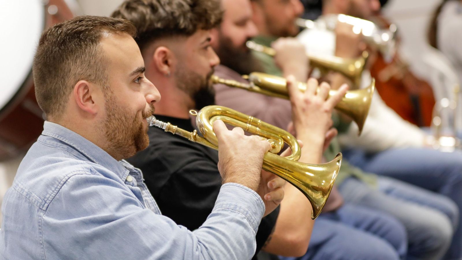 Varios músicos tocan la corneta durante el ensayo de la obra.