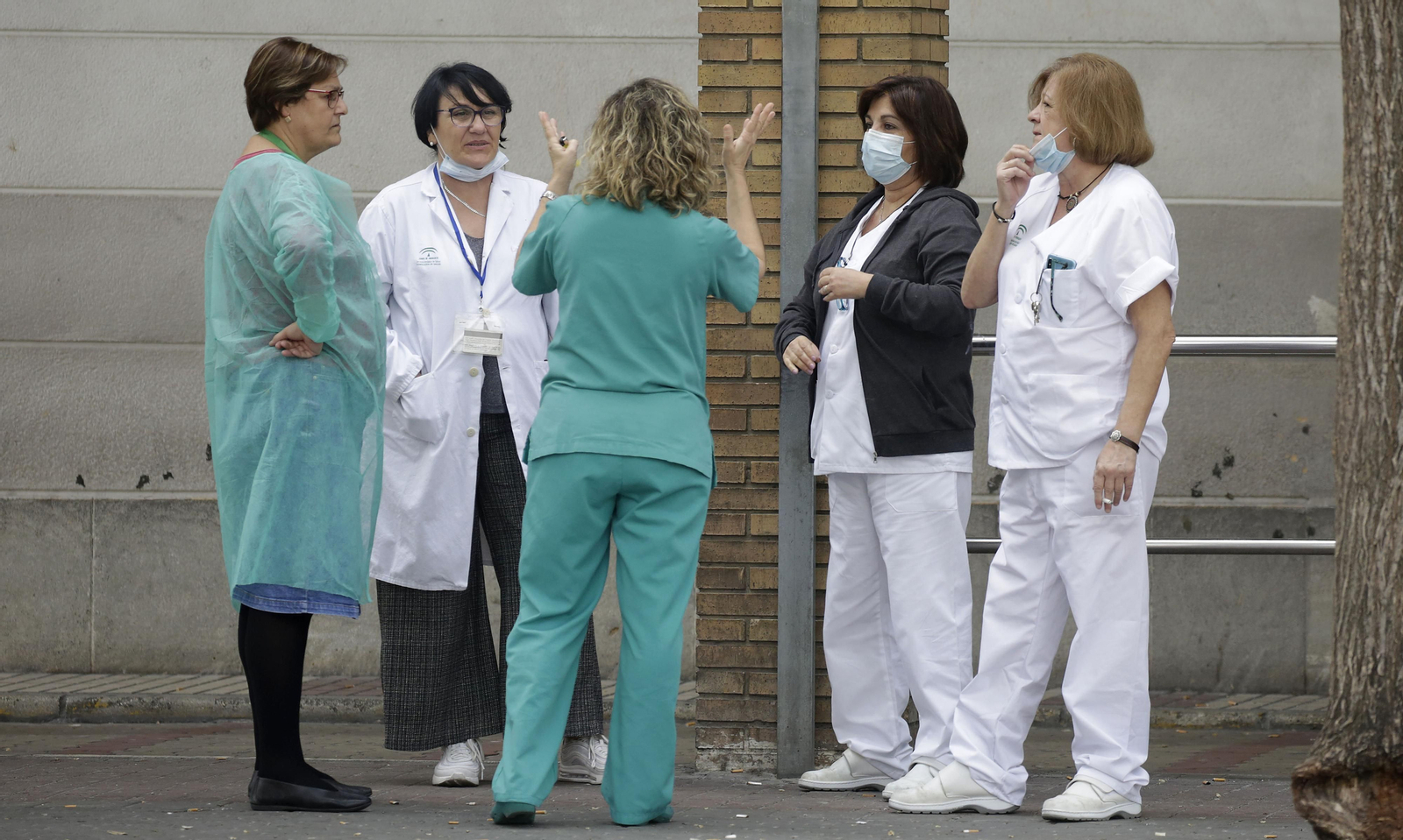 Un grupo de sanitarios conversa en el exterior de un hospital.