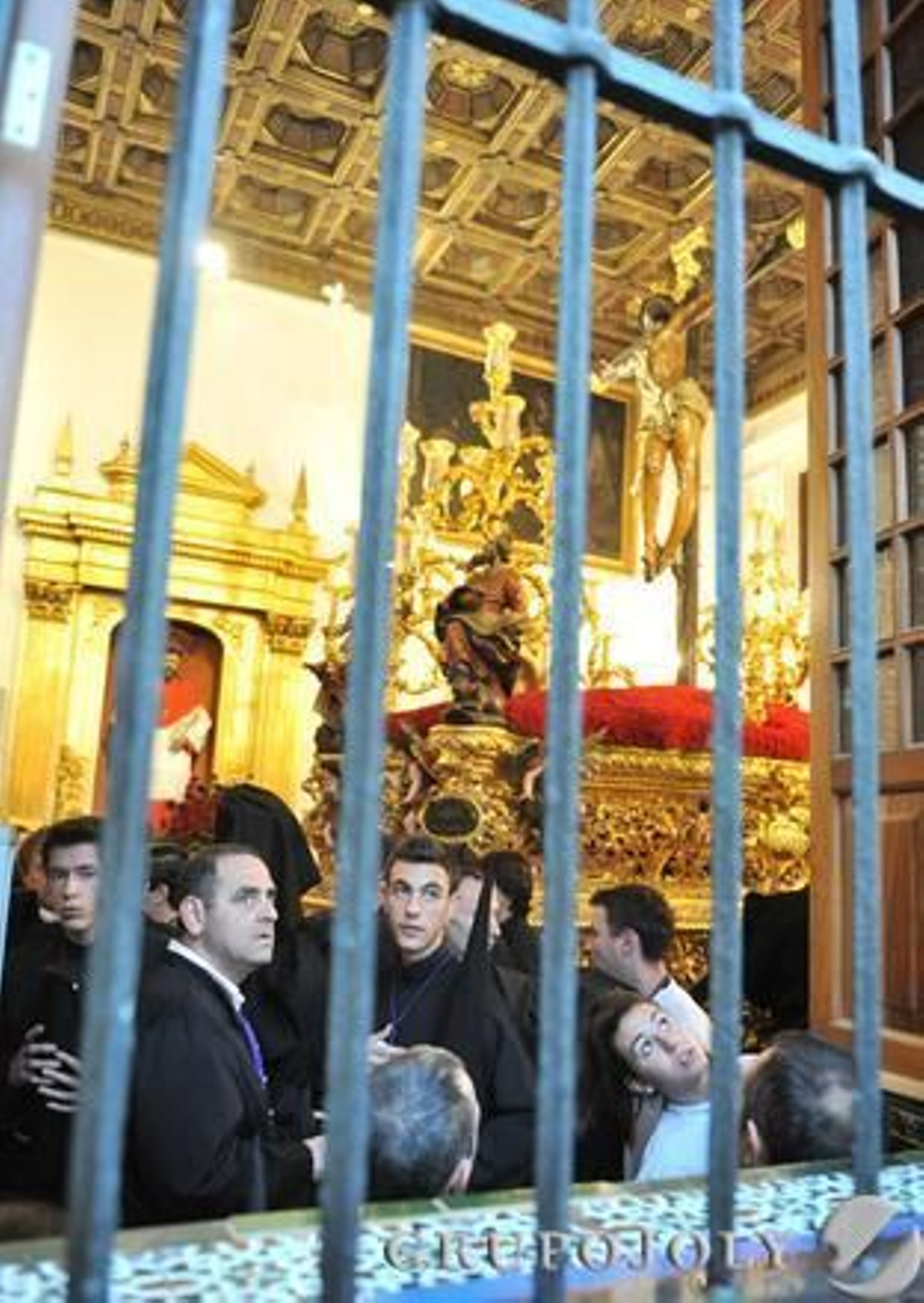 El Cristo de la Expiración en el interior del templo mientras los hermanos miran a la calle para ver el tiempo.

Foto: Juan Carlos Vazquez