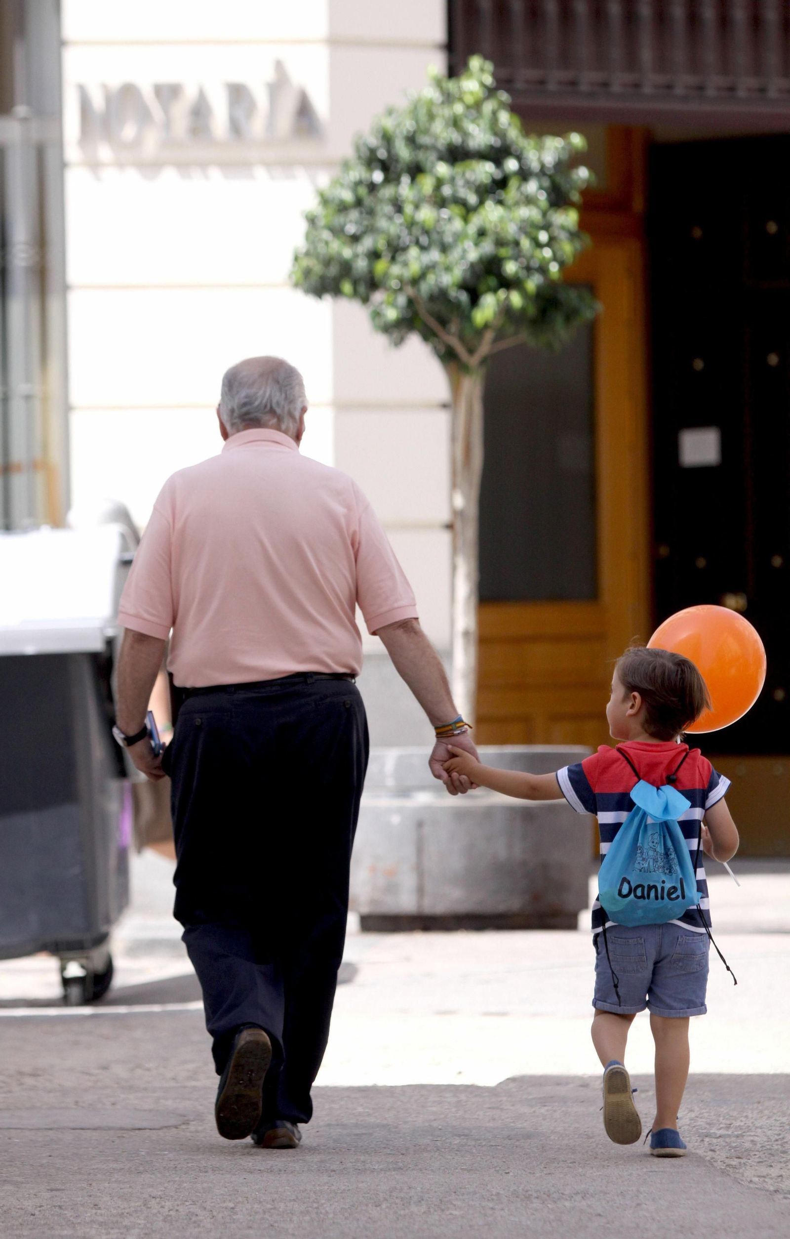 Un abuelo va de la mano de su nieto