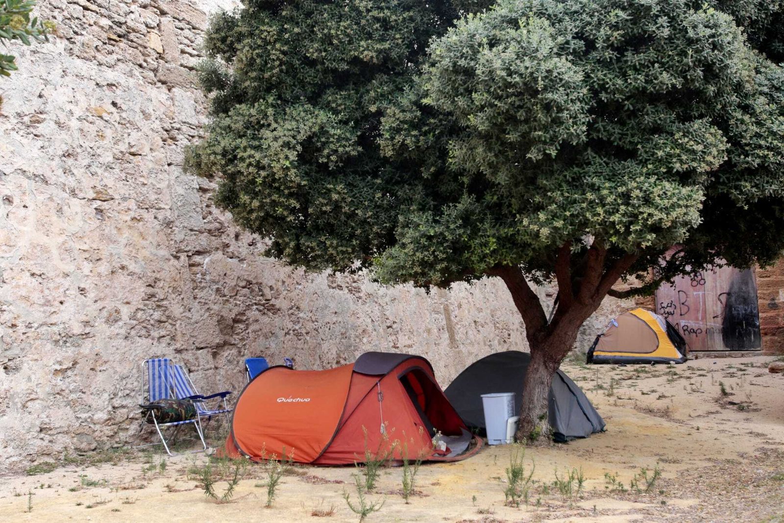 Personas sin hogar acampadas en el foso de las Puertas de Tierra.