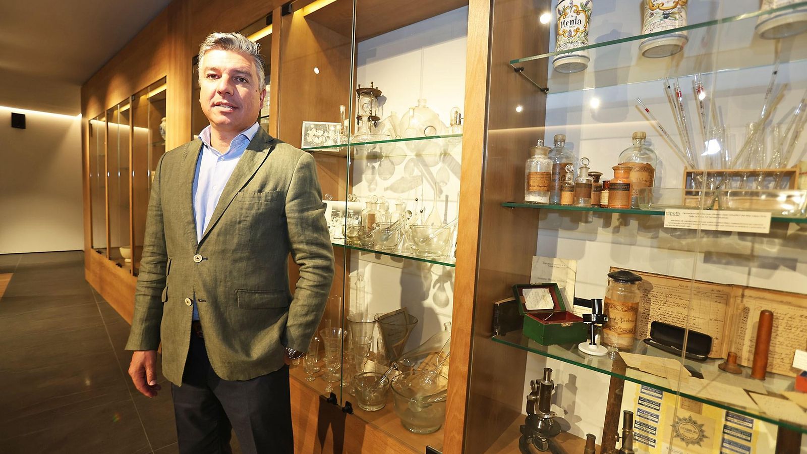 Jorge Juan García junto a algunos 'tesoros' del Colegio de Farmacéuticos de Huelva.