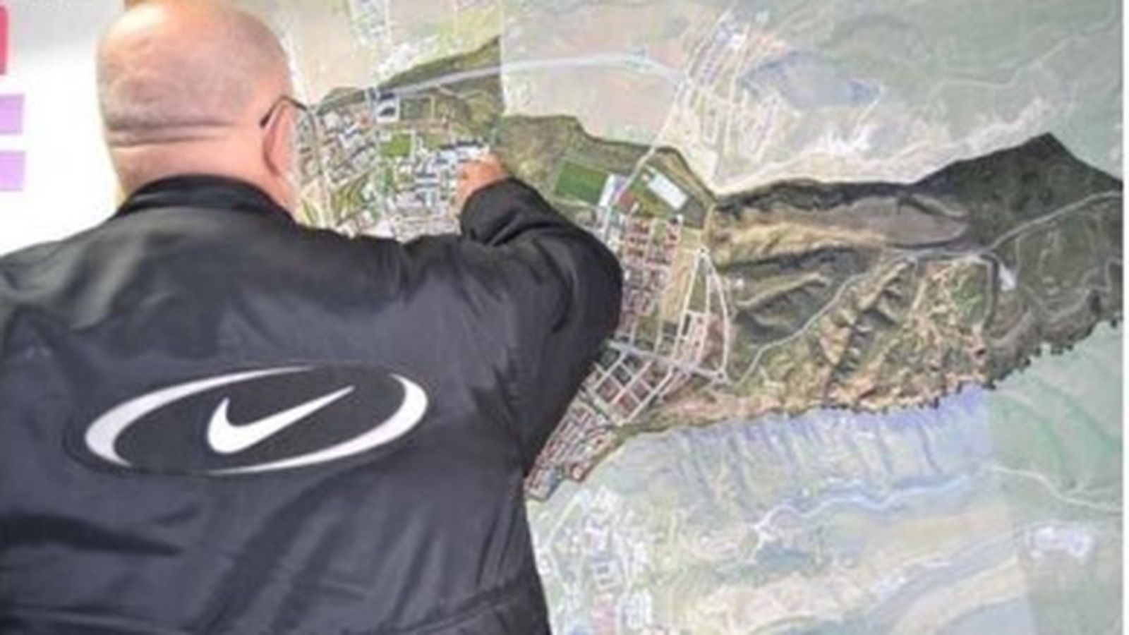 Un vecino observa el mapa del distrito.