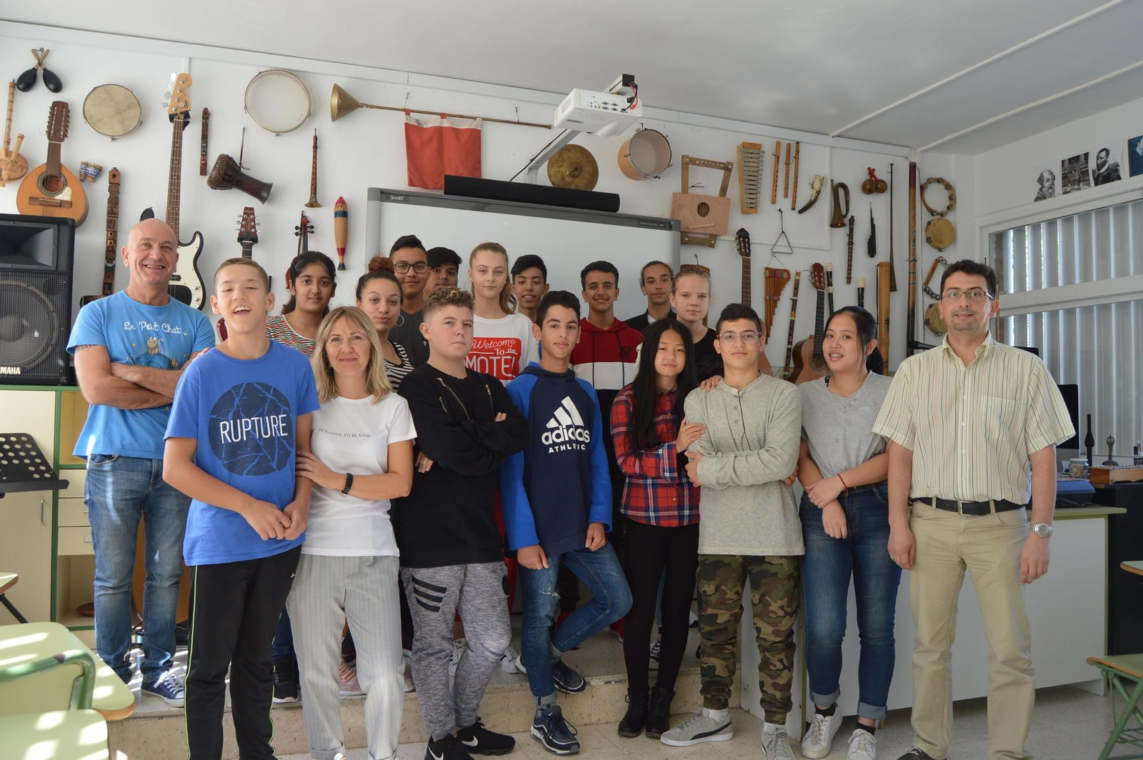 Un grupo de alumnos junto a sus profesores en el aula de música.
