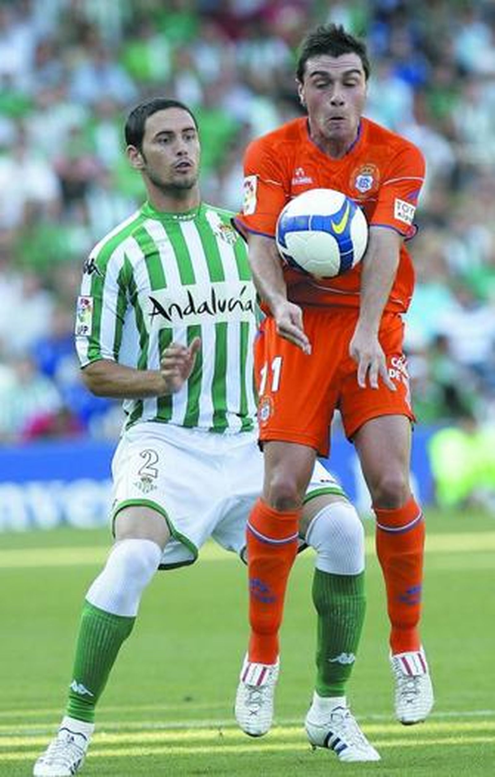 Adrián Colunga controla el esférico con el pecho en presencia de Melli, durante el partido de ayer.