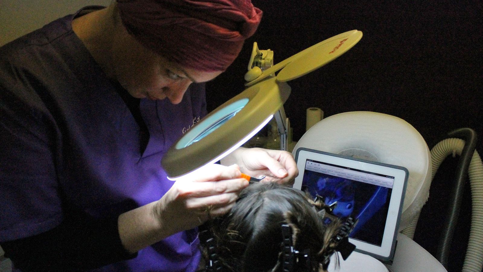 Una experta elimina liendres y piojos a una niña