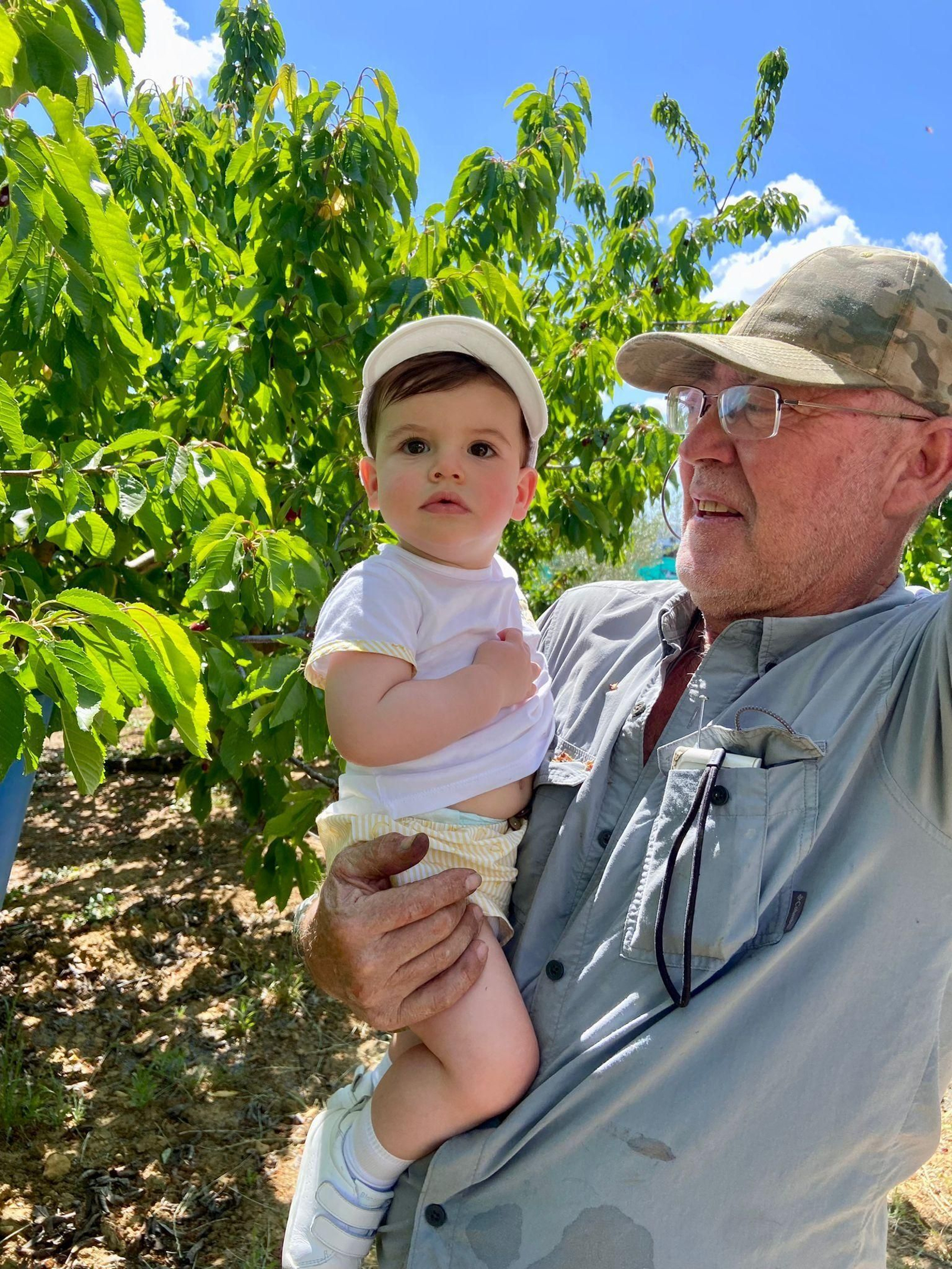 Francisco Ponce, con más de 40 años de emigración a sus espaldas, con su nieto, en el campo.