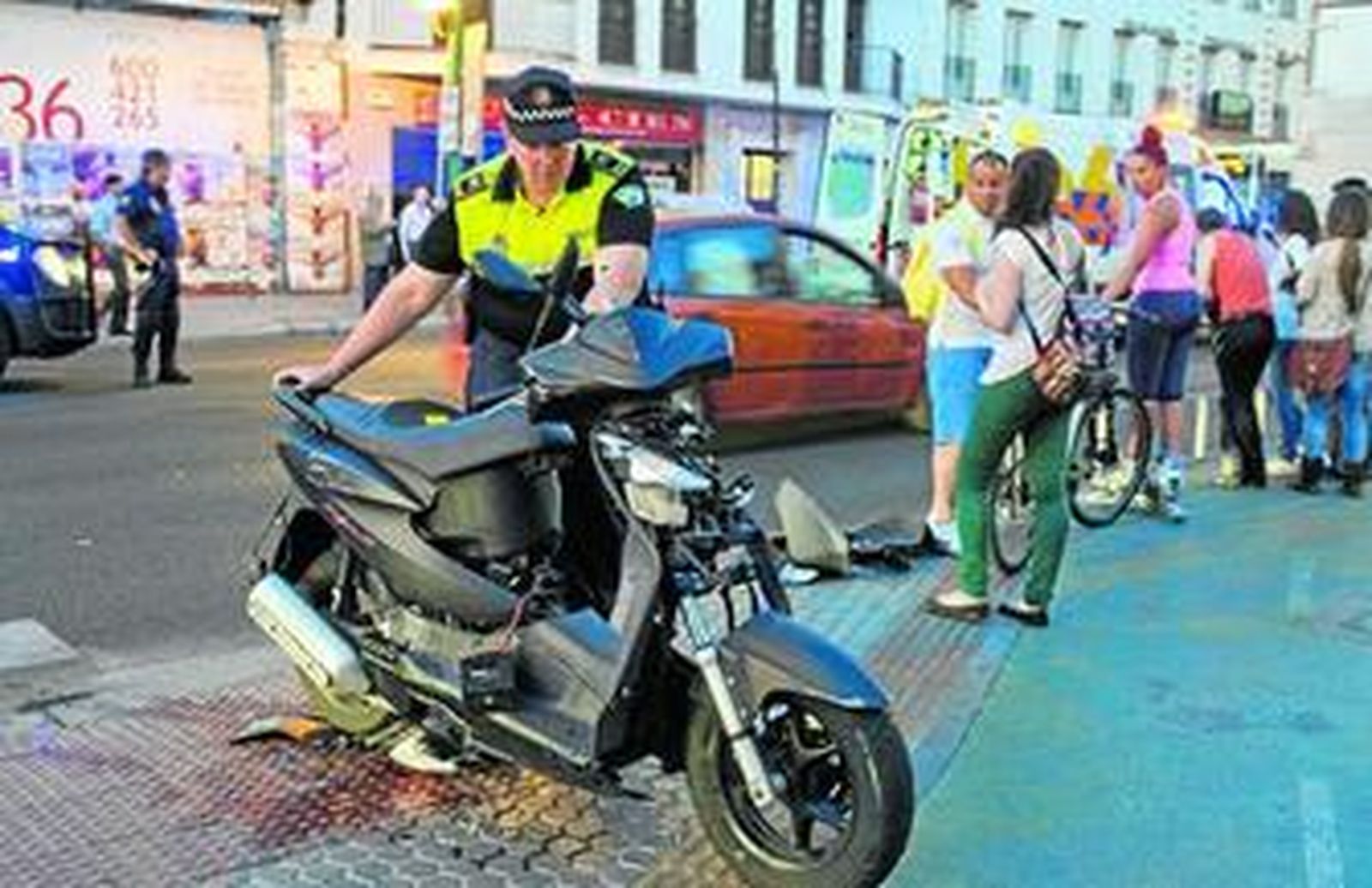 Un policía retira una motocicleta de un accidente en la calle Resolana.