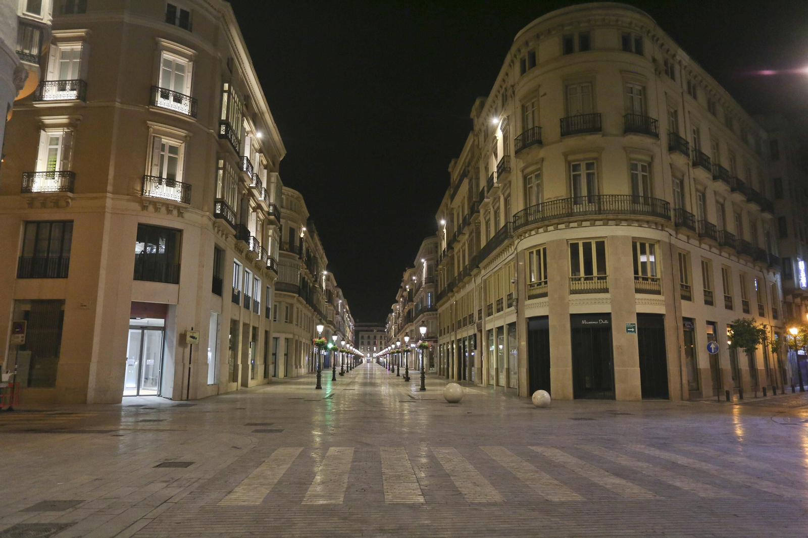 El coronavirus dibuja una noche desierta en el centro de Málaga, en fotos