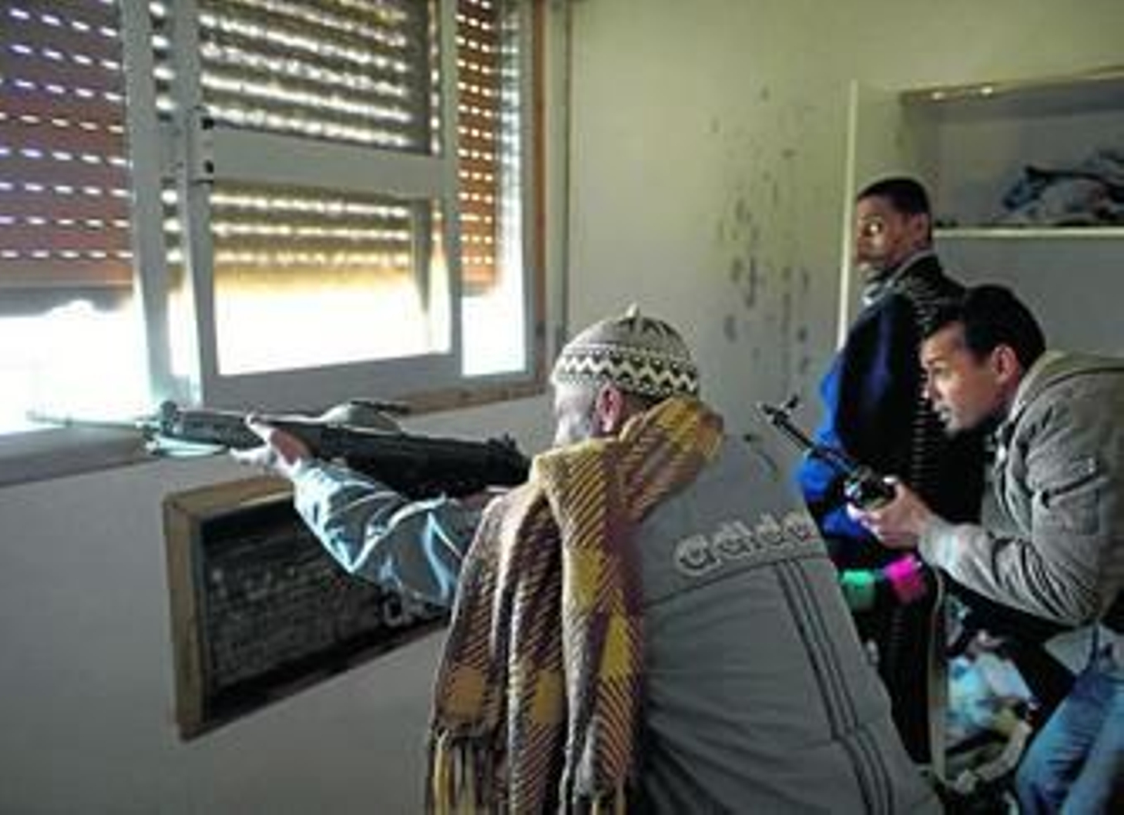 Rebeldes libios disparan contra las fuerzas de Gadafi en la calle Trípoli de Misrata, donde se libran los peores combates.