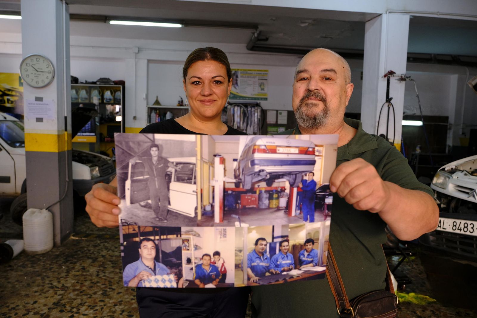 Pepe Gálvez y su hija Silvia, actual propietaria del taller, sostienen un cuadro con fotos que resumen sus 50 años de vida laboral.