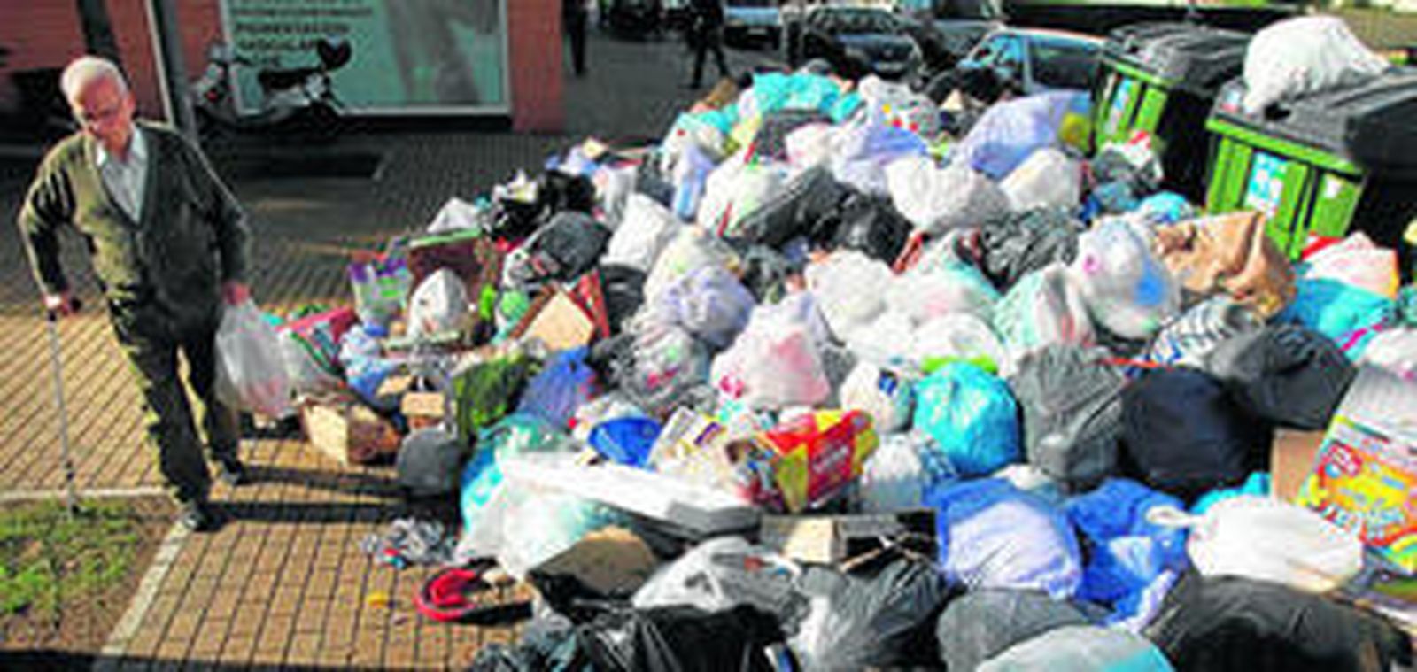 Un señor camina por la poca acera que queda libre ante la acumulación de basura, ayer, en la zona de Palos Blacos.
