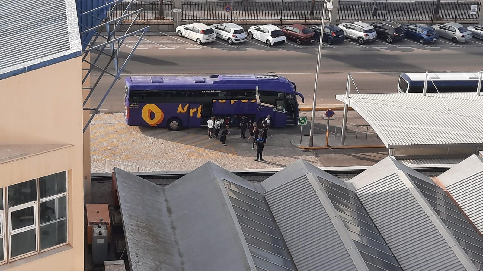 Fotografía realizada  por un crucerista desde el interior del MSC Orchestra en la que se ve uno de los muchos autobuses que trajeron o se llevaron a los portugueses a su tierra de origen