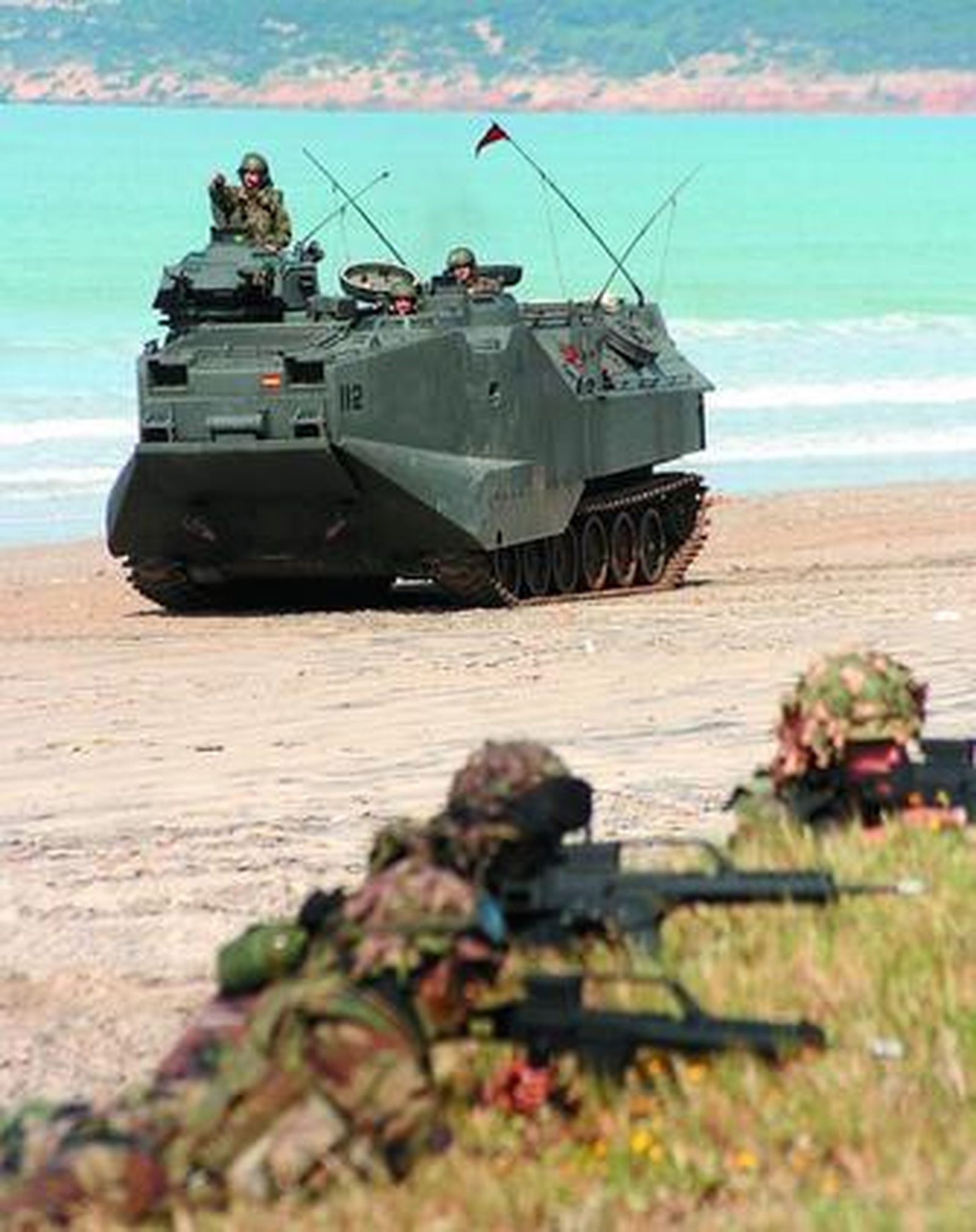 1. La playa del Retín fue tomada ayer por la Armada para mostrar su potencial al Príncipe de Asturias.  2. Su Alteza Real el Príncipe de Asturias saluda al contralmirante Santiago Bolíbar Piñeiro y al general de Brigada Luis Martín de la Hoz a su llegada. 3. Uno de los helicópteros que participaron en el ejercicio aterriza al lado de un grupo de soldados, listos para el asalto al 'Santuario de la guerrilla'. /Fotos: Manuel Aragón Pina