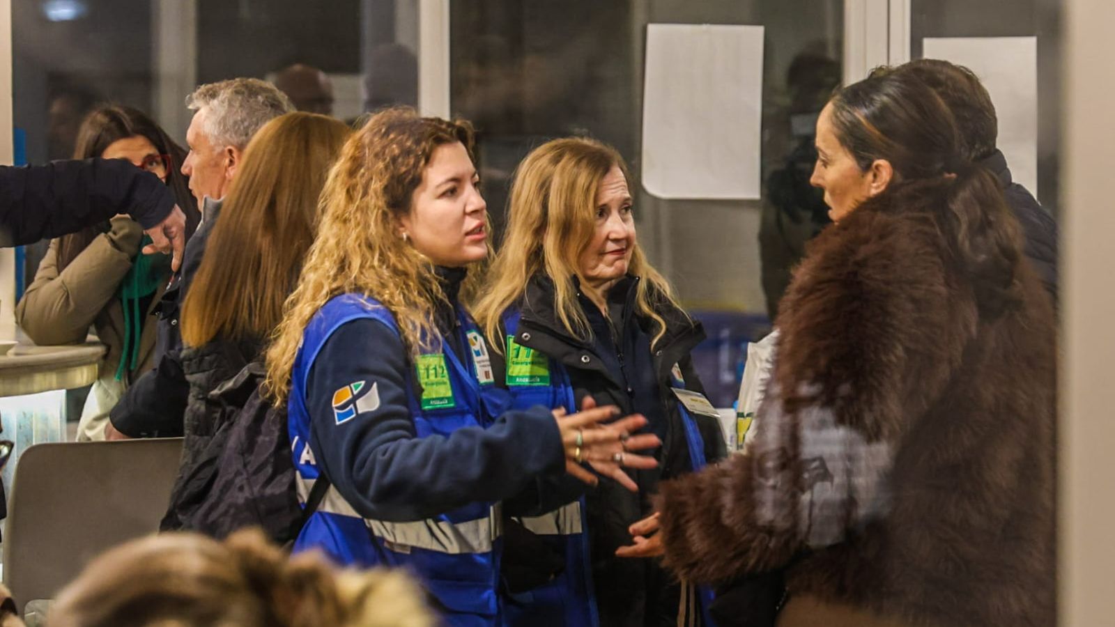 Personal del 112 conversa con una familia onubense en el Hogar del Pensionista de Adamuz.