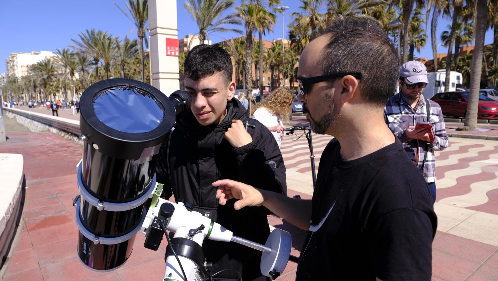 Almería observa el eclipse solar desde el Paseo Marítimo, en imágenes