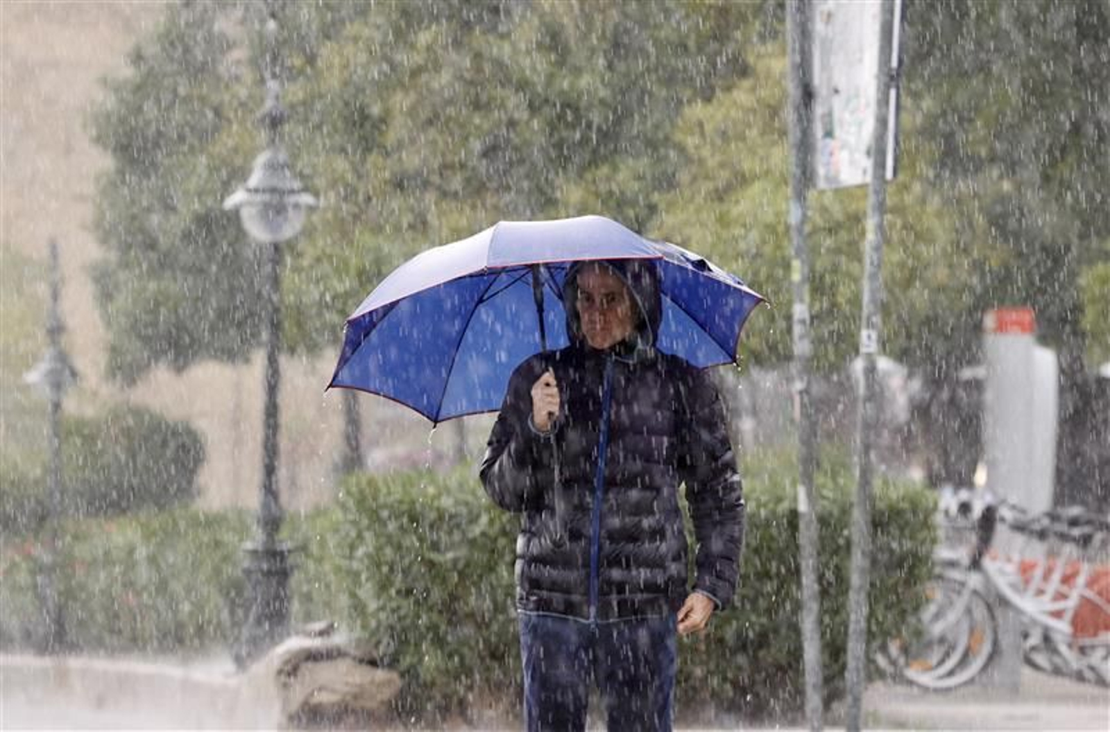 Una persona camina bajo una intensa lluvia en Sevilla