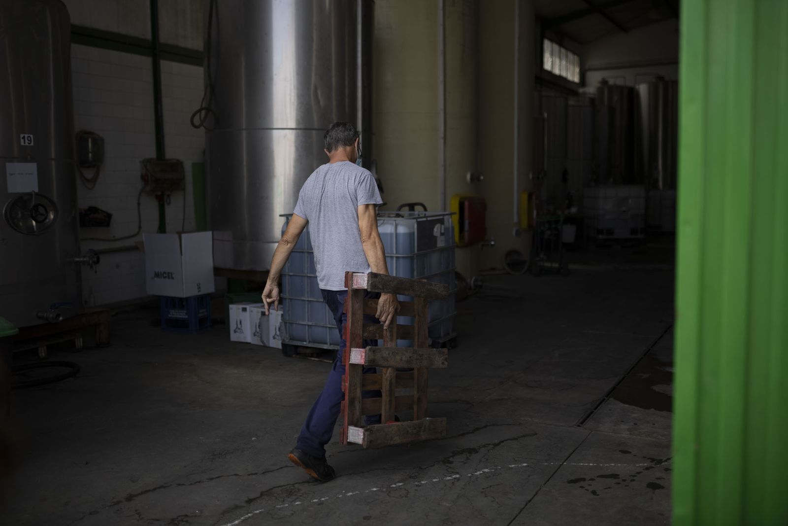 Un joven lleva un palé.