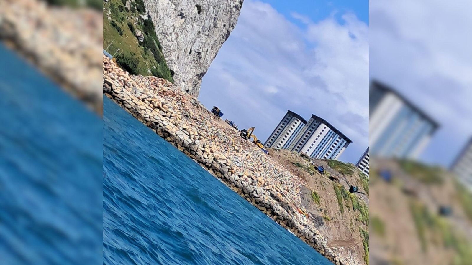 La enorme escollera que Gibraltar construye sobre aguas españolas; en el centro, máquinas excavadoras y al fondo, las Hassan Centenary Terraces, levantadas también sobre terrenos ganados al mar. La enorme escollera que Gibraltar construye sobre aguas españolas; en el centro, máquinas excavadoras y al fondo, las Hassan Centenary Terraces, levantadas también sobre terrenos ganados al mar.