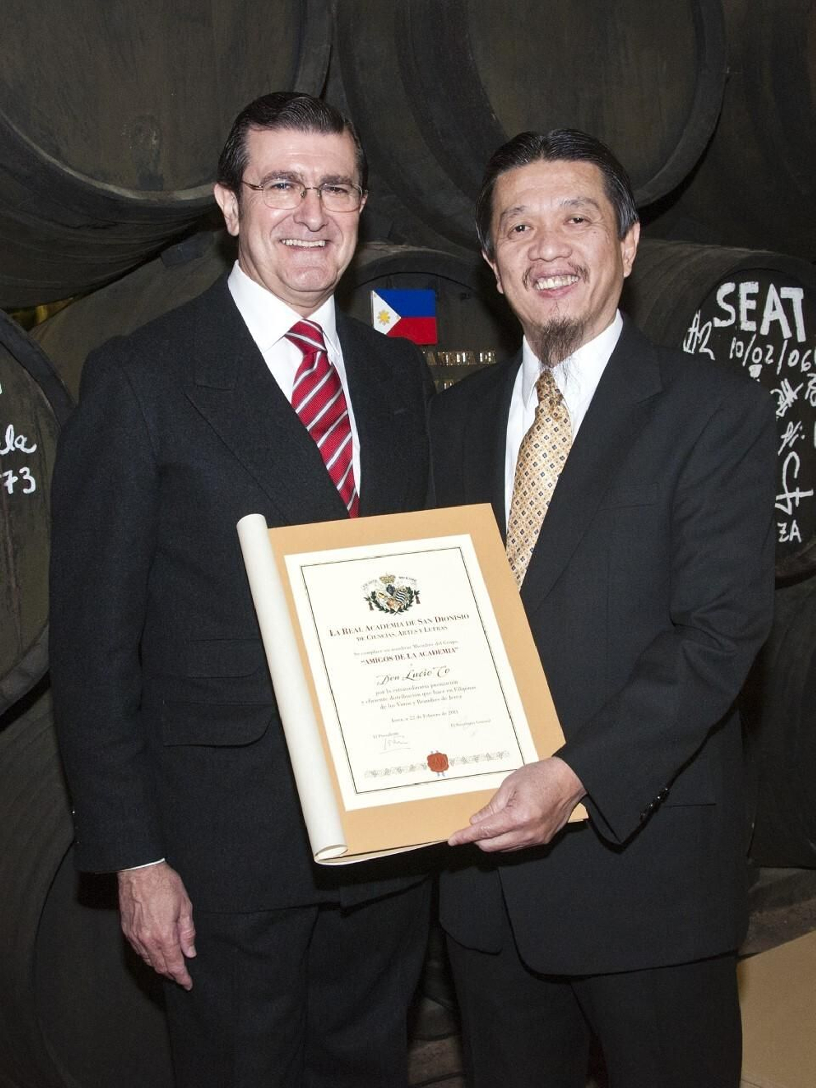 Lucio Co con un diploma distintivo de la Academia de San Dionisio junto a Alfonso Roldán, directivo de Williams que dio nombre al brandy 'Alfonso',