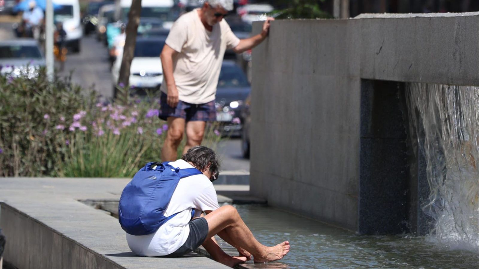 Un joven se lava los pies en la fuente ornamental que está situada en La Malagueta.