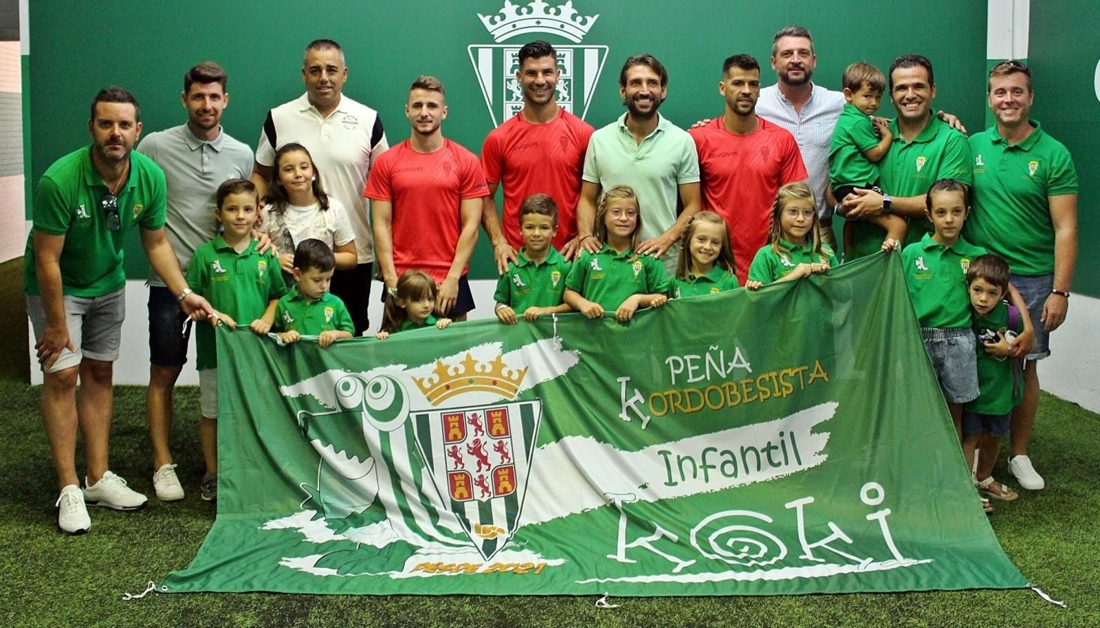 Los integrantes de la peña infantil, con algunos padres, posan con miembros de la plantilla del Córdoba CF.