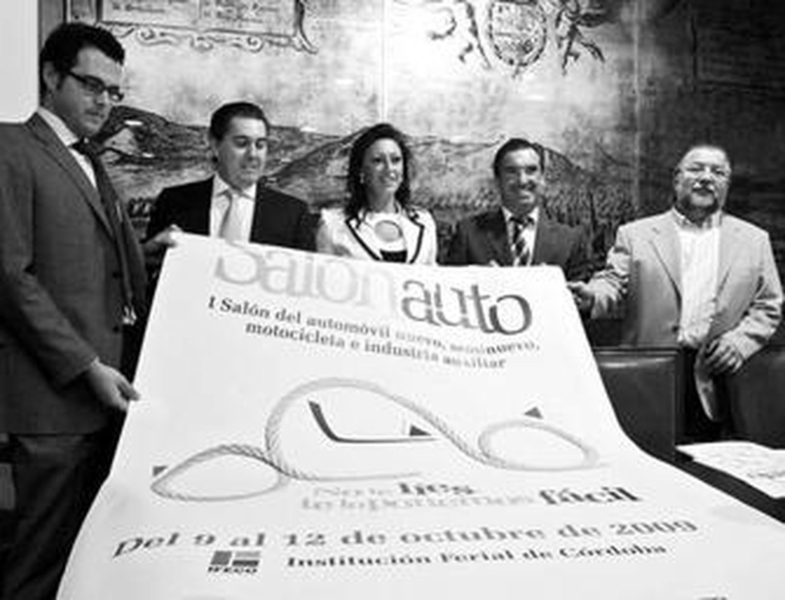 Los responsables del salón del automóvil, muestran ayer el cartel anunciador.