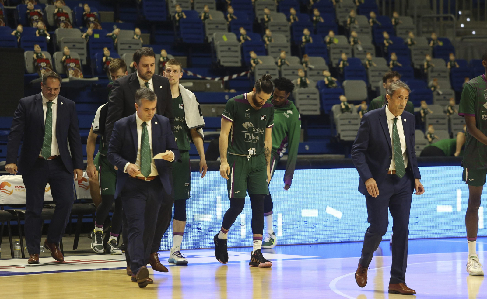 Jugadores y técnicos del Unicaja se retiran cabizbajos.
