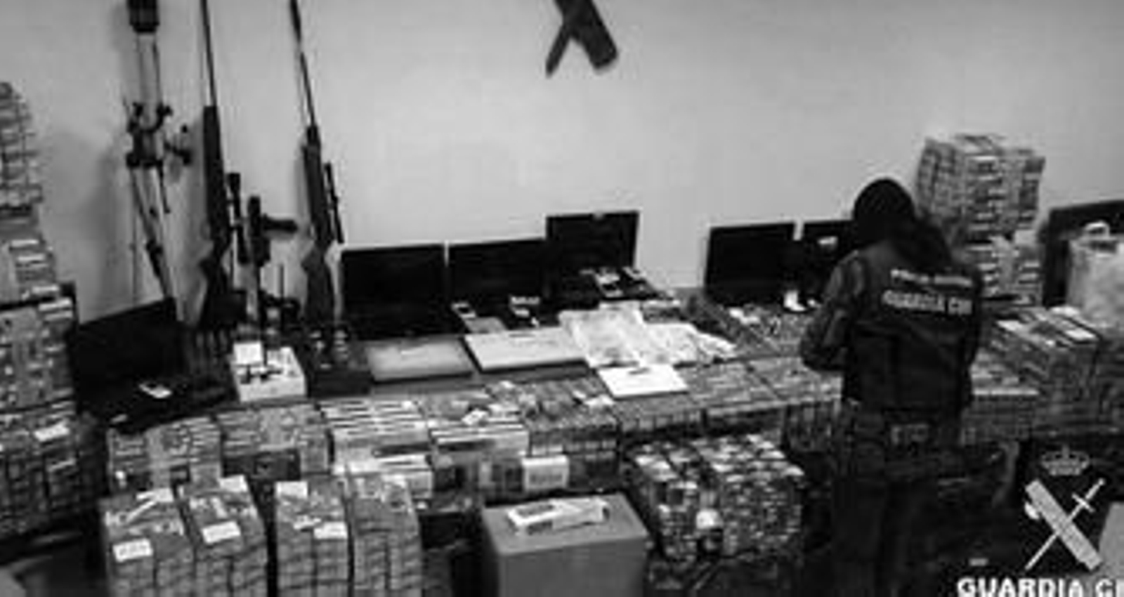 Una agente de la Guardia Civil, ante las cajetillas y las armas intervenidas en la operación.