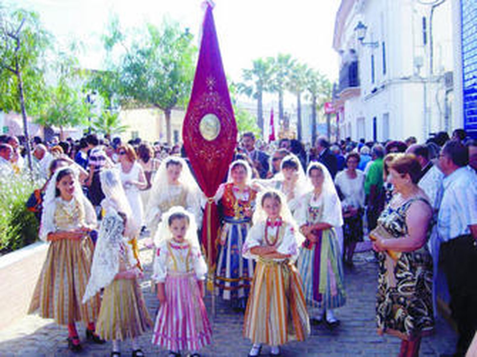 Un grupo de niñas alosneras, con el traje típico, llega al templo por la mañana.