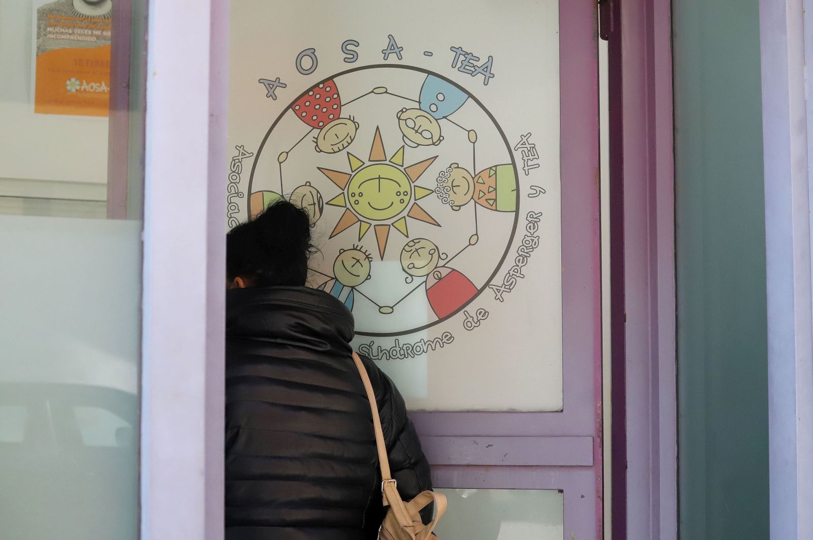 Una mujer entra en el local de la Asociación AOSA TEA de Huelva