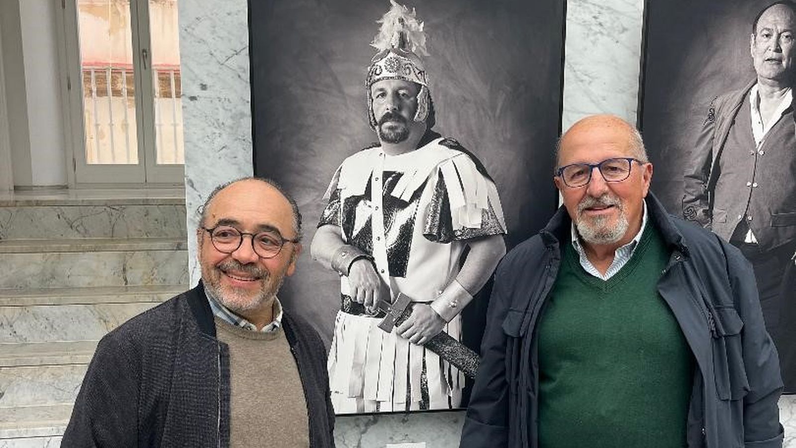 El fotográfo Kiki y Luis Frade ante su foto durante la inauguración.