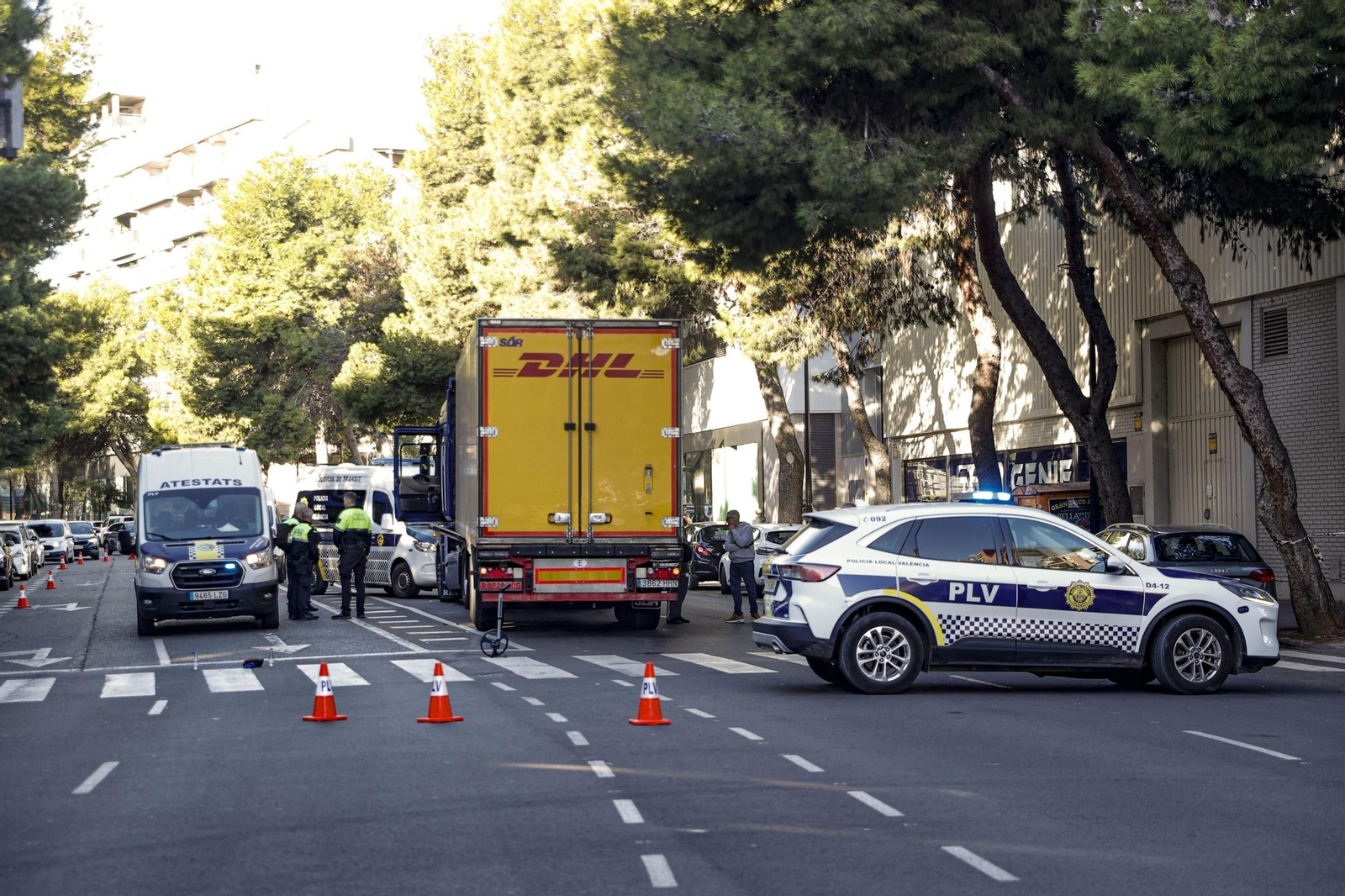 Agentes de atestados de la Policía Local de Valencia trabajan junto al camión en el lugar del atropello.