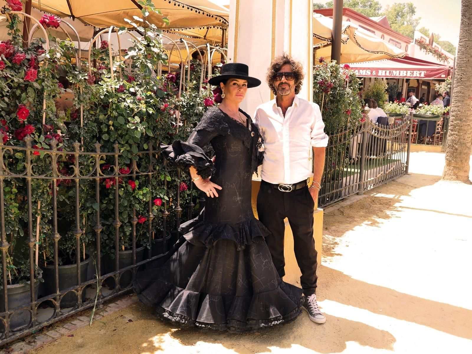 Willie Márquez, junto a su amiga Caroline Coles con el vestido que le ha pintado, en la Feria de Jerez.