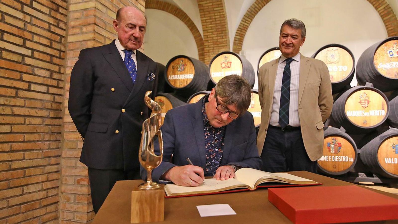 Armitage firma en el libro de honor en presencia del presidente y el director general del Consejo Regulador. Armitage firma en el libro de honor en presencia del presidente y el director general del Consejo Regulador.