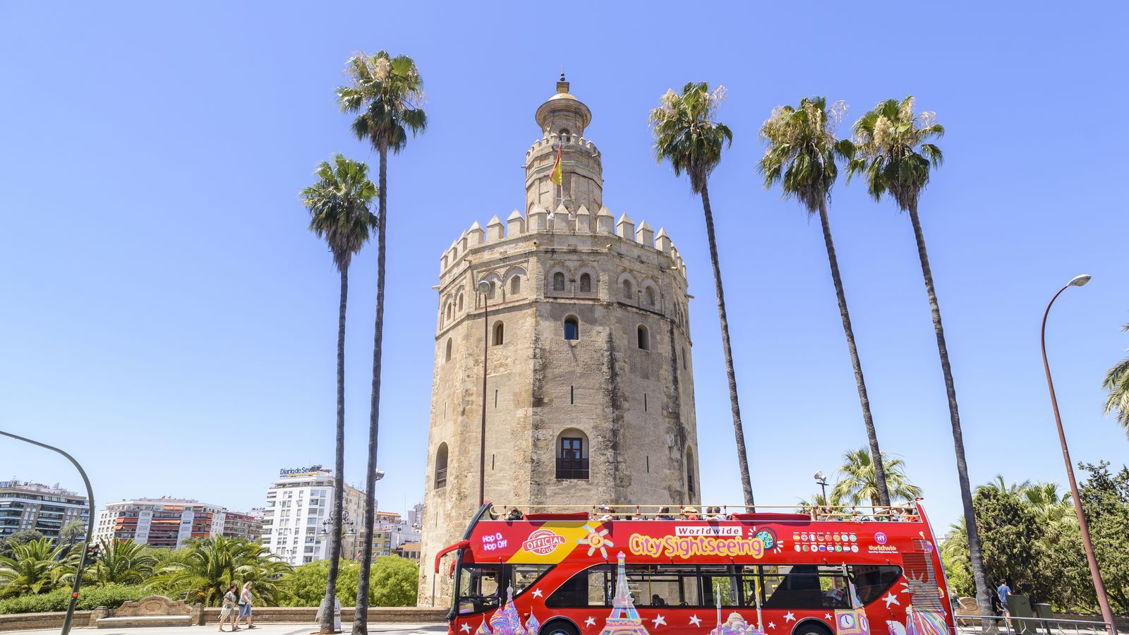 Autobús turístico a su paso por la Torre del Oro