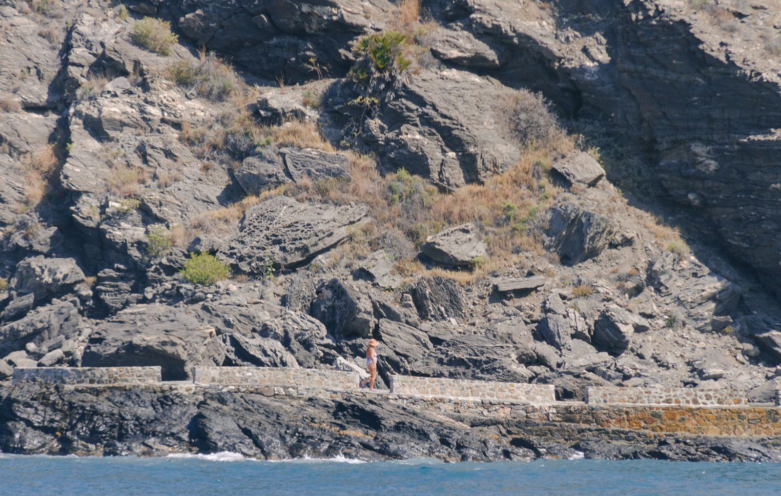 Una mujer paseando por un camino junto al mar de Salobreña