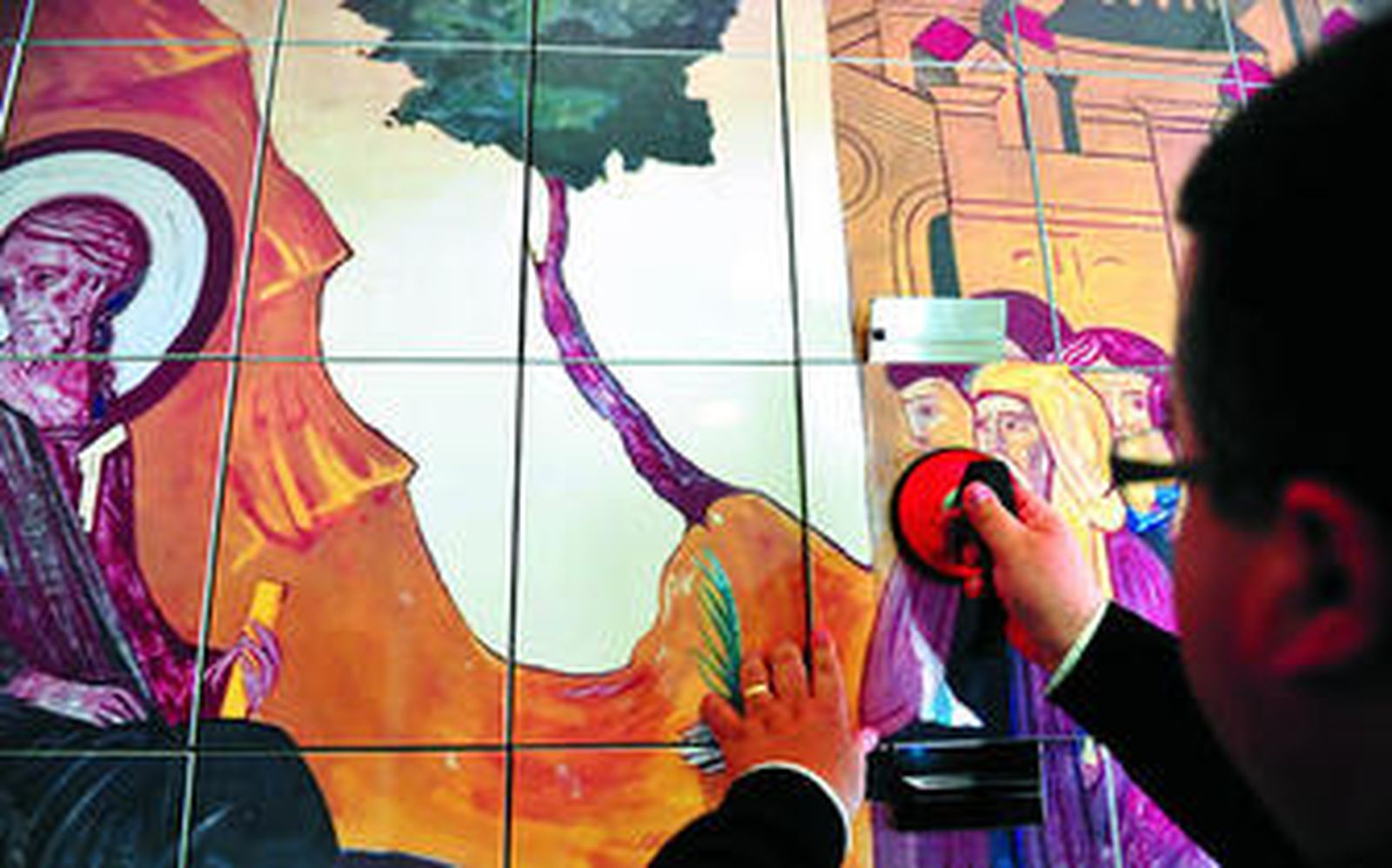 El párroco Rafael Vez muestra el procedimiento de apertura del mosaico del columbario de San José Artesano en el que reposan las cenizas de los difuntos.